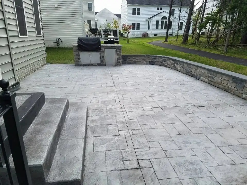 A modern concrete patio with outdoor kitchen setup, designed by Concrete Invercargill to enhance outdoor living.